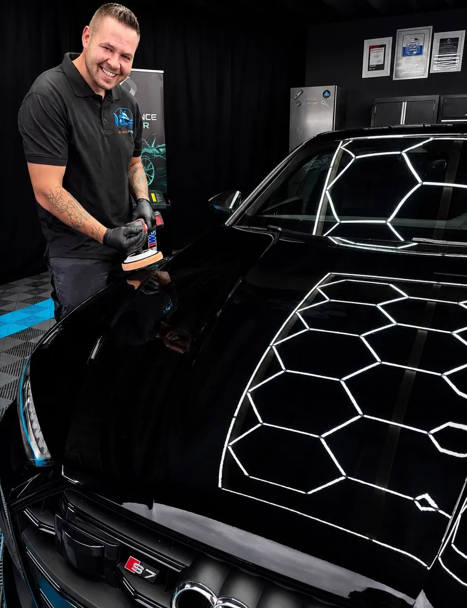 Professioneller Detailer mit Poliermaschine in moderner Werkstatt